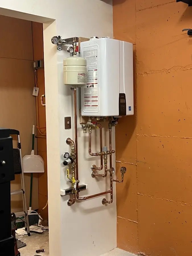 Plumbing technician inspecting water heater connections in Mount Gilead